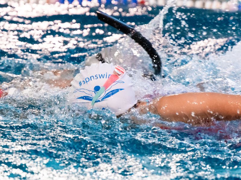 Пловец кролем с трубкой в шапочке #spnswim, динамичный кадр, в школе плавания SPN