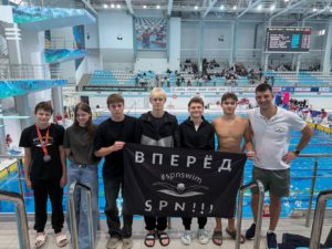 Команда школы плавания SPN с баннером «Вперёд #spnswim SPN!!!» у бассейна, 4 этап «Рузского фарватера»